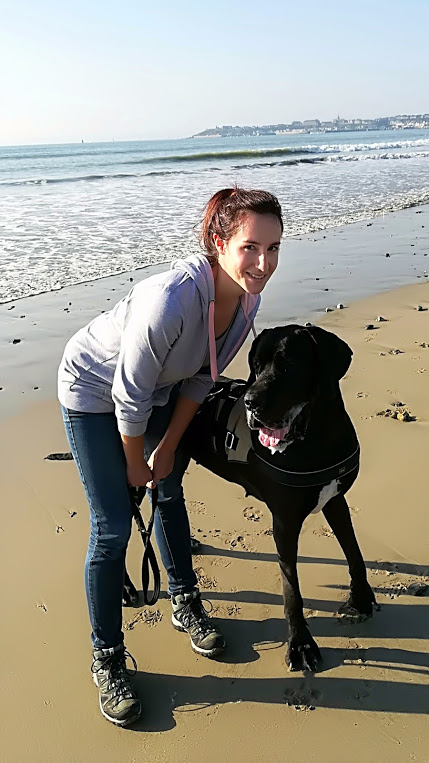 Diane Bourin, magnétiseur chien, sur une plage avec sa chienne Jenna de race dogue allemand.
